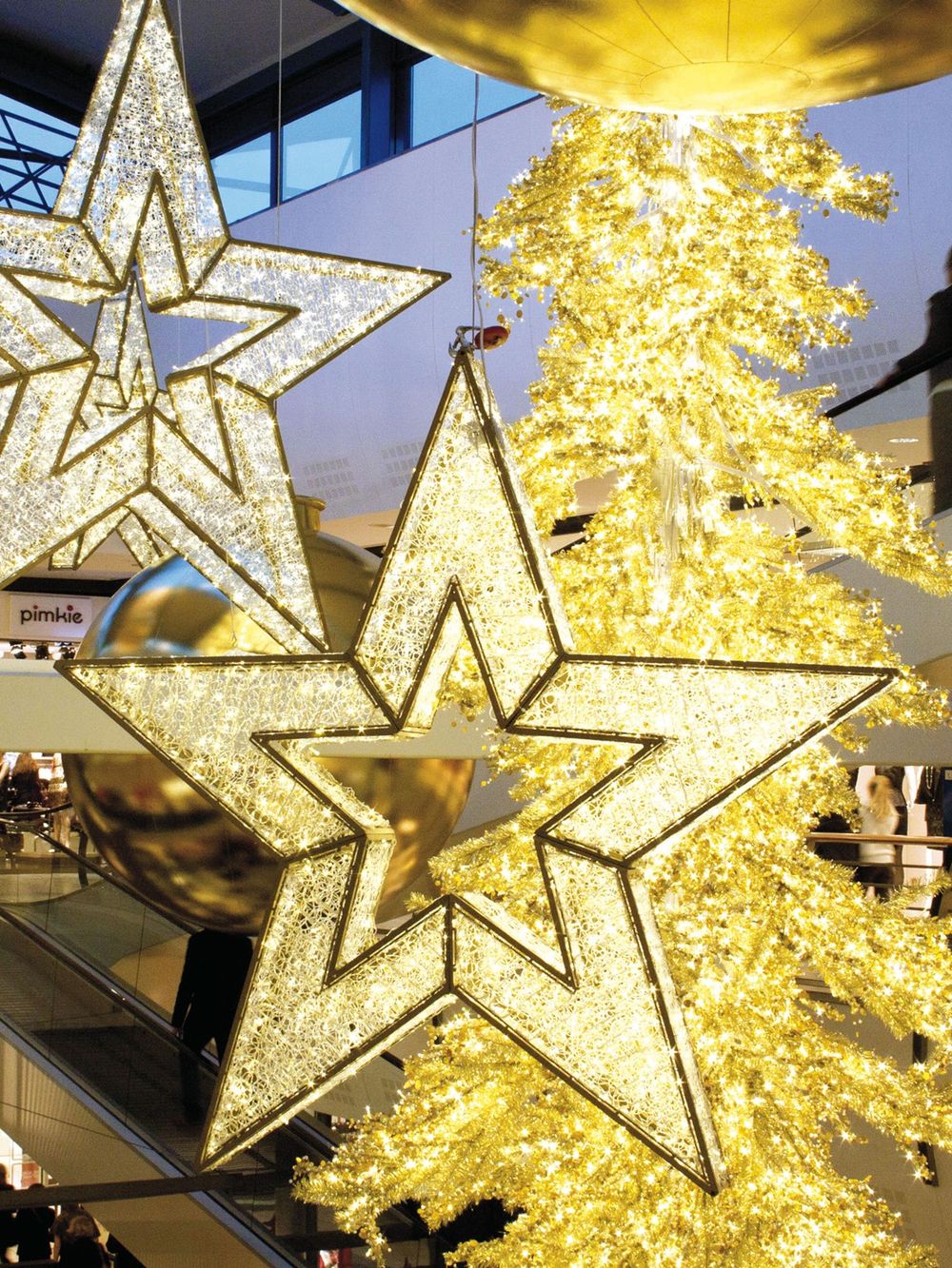 Stórar upplýstar stjörnur hanga í verslunarmiðstöð